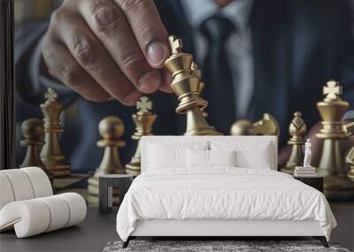 CLOSE UP OF A BUSINESSMAN'S HANDS MOVING A GOLD CHESS KING ON A CHESS TABLE Wall mural