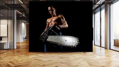 fitness muscular male model with chainsaw Wall mural