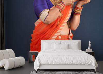 Happy traditional Indian woman wearing saree holding and posing with Ganesha statue on the occasion of Ganesh Festival Wall mural