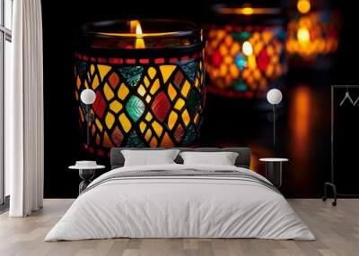 Three intricately designed candle holders emit a warm glow in a dark setting, showcasing vibrant colors and patterns. The flickering light creates a cozy atmosphere perfect for relaxation. Wall mural