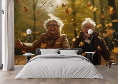 Active seniors having fun and playing with the leaves in autumn forest. Healthy and active elderly couple. Happy couple on retirement, healthy and active lifestyle. Wall mural