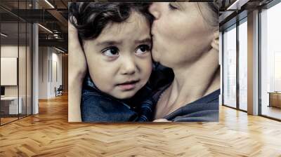 A woman holds a child, trying to calm him down. The child is three years.
 Wall mural