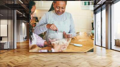 African mother and daughter preparing healthy cake at home - Baking, family lifestyle concept - Focus on mom's face Wall mural