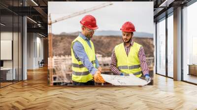 Builders on residential construction site looking the building project Wall mural