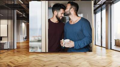 Gay male couple having tender moment while washing dishes inside home kitchen - Focus on faces Wall mural