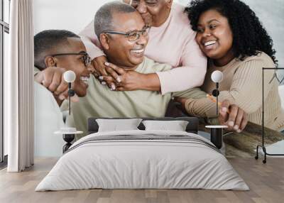 Happy black family eating lunch at home - Father, daughter, son and mother having fun together sitting at dinner table - Main focus on man face Wall mural