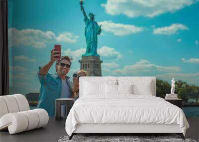 Happy couple taking a selfie in new york with the statue of liberty in background during honeymoon vacation - Soft focus on man face - Models by AI generative Wall mural