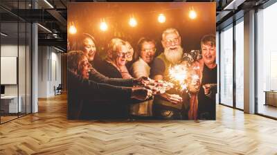 Happy family celebrating with sparkler fireworks on new year's eve - Focus on left hands Wall mural