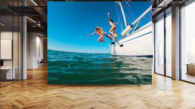 Happy friends diving from sailing boat into the sea - Travel and summer vacation concept - Soft focus on blond girl face Wall mural