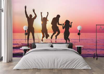 Happy friends jumping inside water on tropical beach at sunset Wall mural