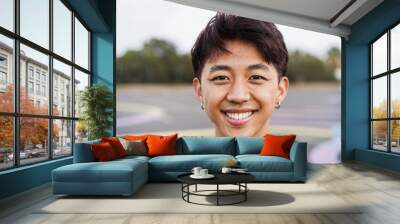 Happy gay chinese man with make-up smiling on camera outdoor - Focus on face Wall mural