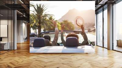 Happy people having fun in convertible car in summer vacation at sunset - Young couple enjoyng  holiday on cabriolet auto outdoor - Travel, youth lifestyle and wanderlust concept - Main focus on hat Wall mural