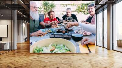 Happy senior friends eating at barbecue home backyard dinner - Mature people having fun at bbq meal in villa's patio - Summer lifestyle and food concept - Main focus on left hipster man face Wall mural