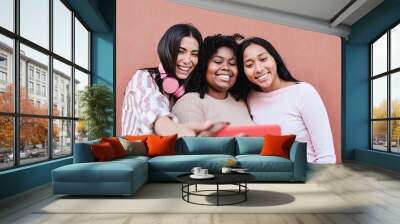 Hispanic girls having fun together in the city while taking selfie with mobile phone - Main focus on right girl Wall mural