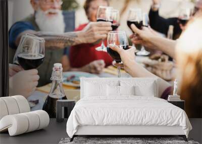 Multi generational people cheering with wine and eating outdoors at home - Focus on center hand holding glass Wall mural