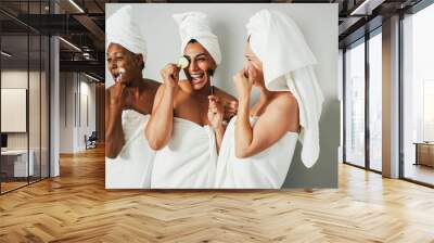 Multigenerational women having fun using skin care products - Focus on center female face Wall mural