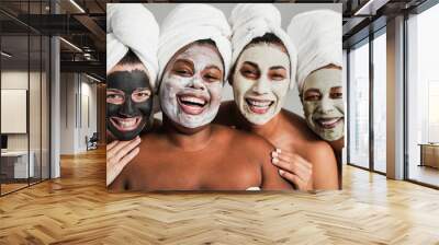 Multigenerational women having fun wearing face beauty mask for skin care therapy - Main focus on african girl face Wall mural