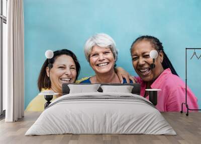 Multiracial senior women having fun hugging together outdoor - Focus on center woman face Wall mural