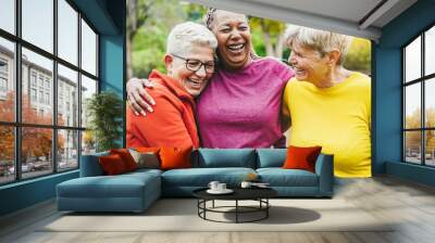 Multiracial senior women having fun together after sport workout outdoor - Focus on left woman face Wall mural