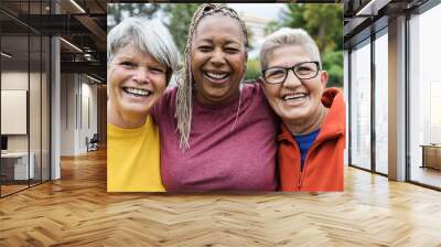 Multiracial senior women having fun together after sport workout outdoor - Main focus on right female face Wall mural