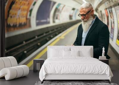 Senior hipster man using smartphone in subway underground - Main focus on hand holding mobile phone Wall mural