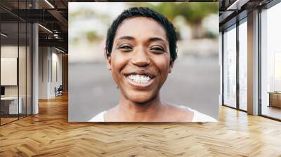 Young african woman smiling on camera outdoor - Focus on face Wall mural