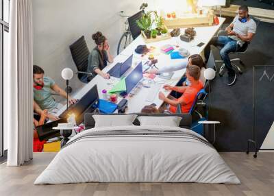 Young co-workers team talking during startup - Happy people planning a new project in creative workplace office - Technology, entrepreneur, marketing and concept - Focus on top right guys Wall mural