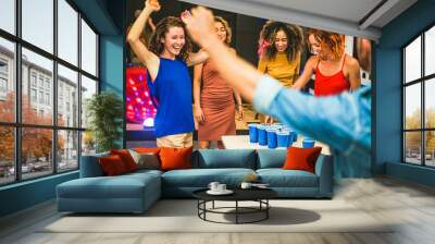 Young friends playing beer pong in hostel bar - Happy trendy people having fun doing party at night in holiday vacation - Friendship, fest and nighlife concept - Focus on center afro girl face Wall mural