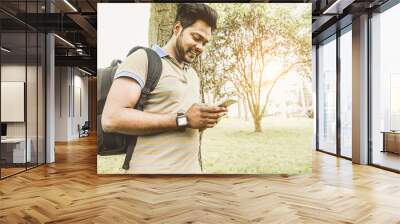 Young indian student using smartphone app outdoor Wall mural