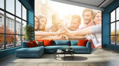 Young millennials friends stacking hands together Wall mural