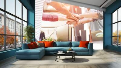 Young teamwork stacking hands together for new startup in creative office Wall mural