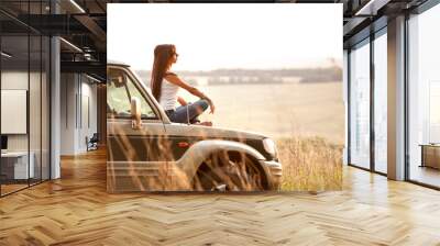 woman is sitting on the car's hood Wall mural