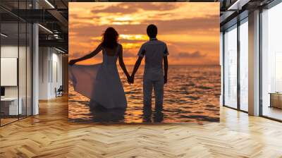 Beautiful wedding photoshoot of a couple. Beautiful bride in white wedding dress and groom having fun on shore sea. Tropical sea in the background. Summer vacation concept. Sunset on the ocean Wall mural