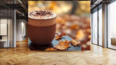 hot chocolate or coffee in a mug during autumn fall time surrounded by nature and dried up orange maple leaves to signify the changing of seasons. Closeup of hot chocolate with whipped cream Wall mural