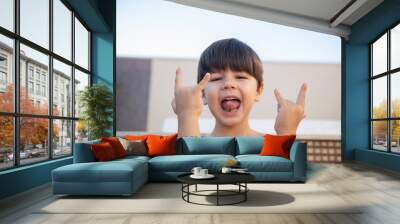 Boy without a shirt with a rocker attitude. Wall mural