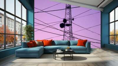 Vertical shot of a telecommunications tower and wires against the purple sky backdrop Wall mural