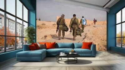 Back shot of several soldiers of israel army walking with israel national flag. Military man walking with other soldiers. War tactical exercise. infantry retreat from positions Wall mural