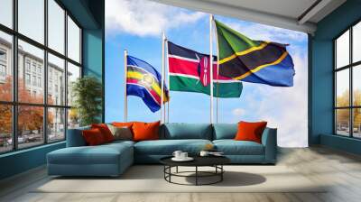 EAC, East African Community flag, flags of Kenya and Tanzania against cloudy blue sky Wall mural