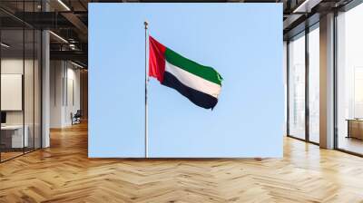 UAE flag waving in the blue bright sky, national symbol UAE Wall mural