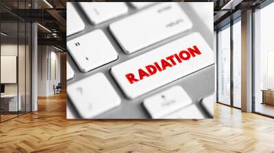 Radiation is energy that comes from a source and travels through space at the speed of light, text concept button on keyboard Wall mural