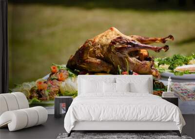 Roast duck is entirely among the dishes of fish and meat in the open air. The main focus is on the duck. Wall mural