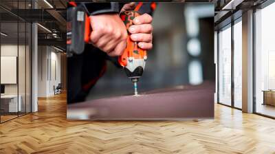 Worker tightens a screw with an electric screwdriver Wall mural