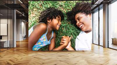 mother and little daughter looking at each other smiling and happy. Wall mural