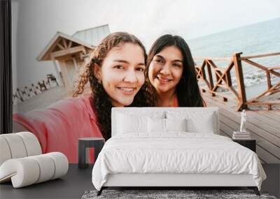 Two friends women with brackets taking a photo in the tourist dock of the city of la Ceiba. Wall mural