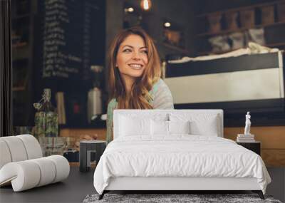 Beautiful young woman sitting in a cafe waiting her boyfriend Wall mural