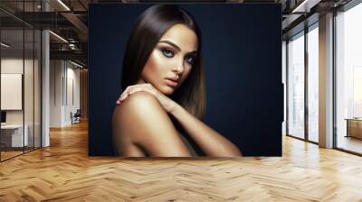 Beauty portrait of a young woman in the studio on a dark background Wall mural