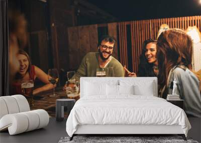 Group of friends drink beer on the terrace during summer night Wall mural