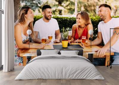 group of young people have a good time in backyard at a wooden table and drink beer Wall mural