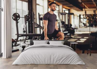 Handsome man legs workout with kettlebell in the gym Wall mural