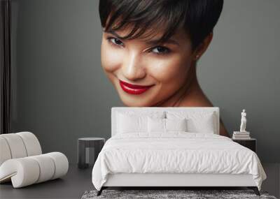 Portrait of beautiful young woman with short hair and red lipstick on her lips isolated on studio background Wall mural